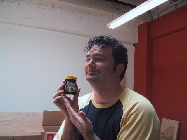 Tim holding a jar of Marmite and looking pleased